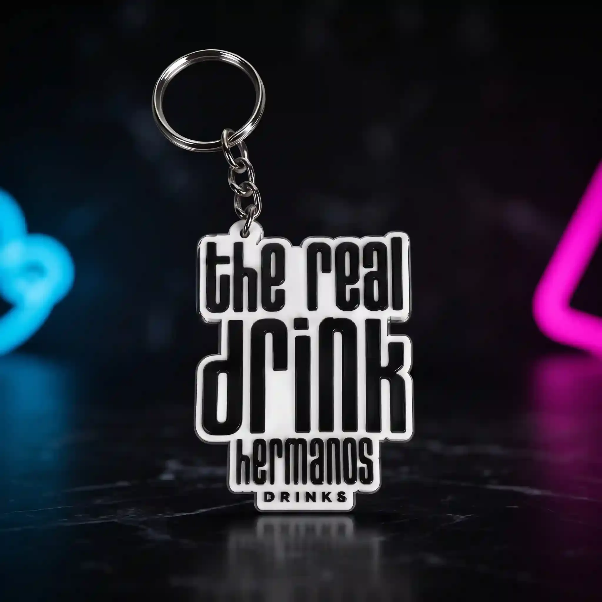 Llavero The Real Drink — El lema de la casa en llavero, con el logo debajo